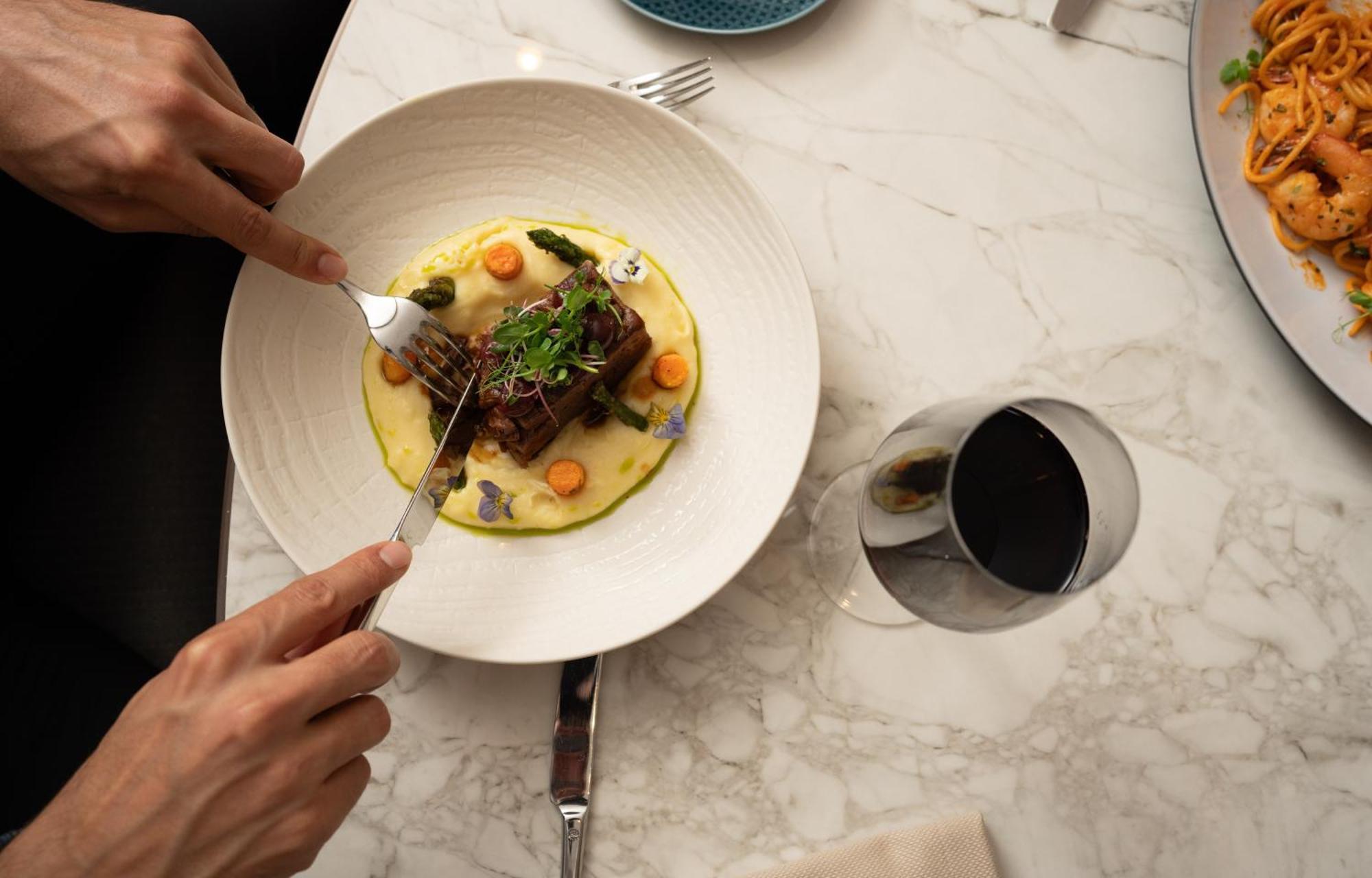 Address Istanbul Hotel Eksteriør billede A person using a fork to cut into a meal